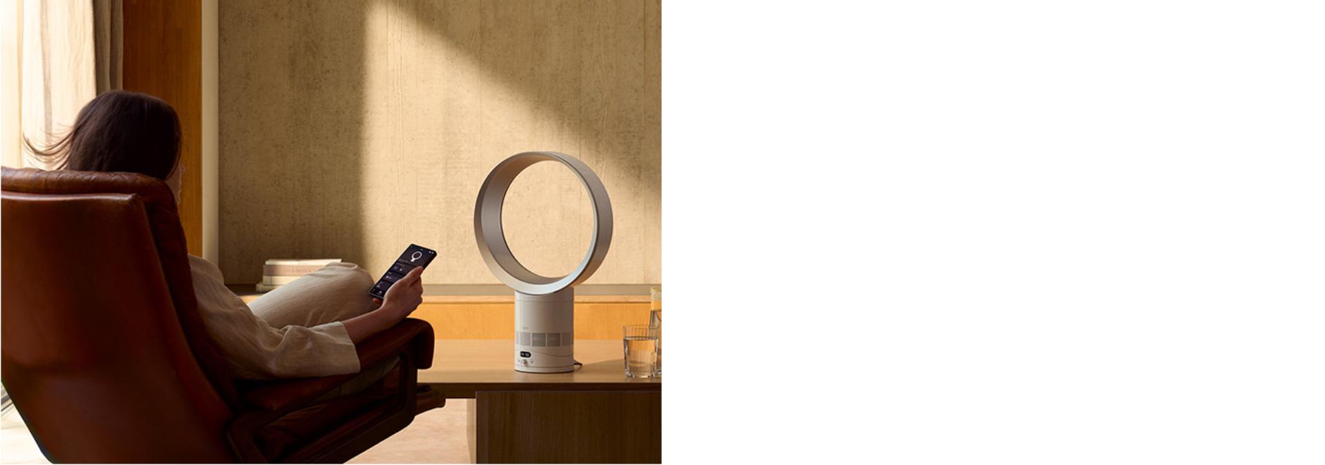 The Dyson Cool CF1 delivering a cool breeze to a person relaxing in a chair.
