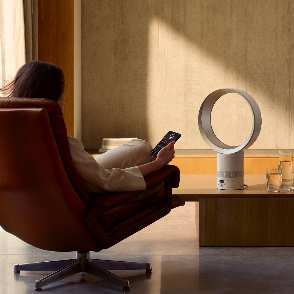 The Dyson Cool CF1 delivers a cool breeze to a person in a chair.