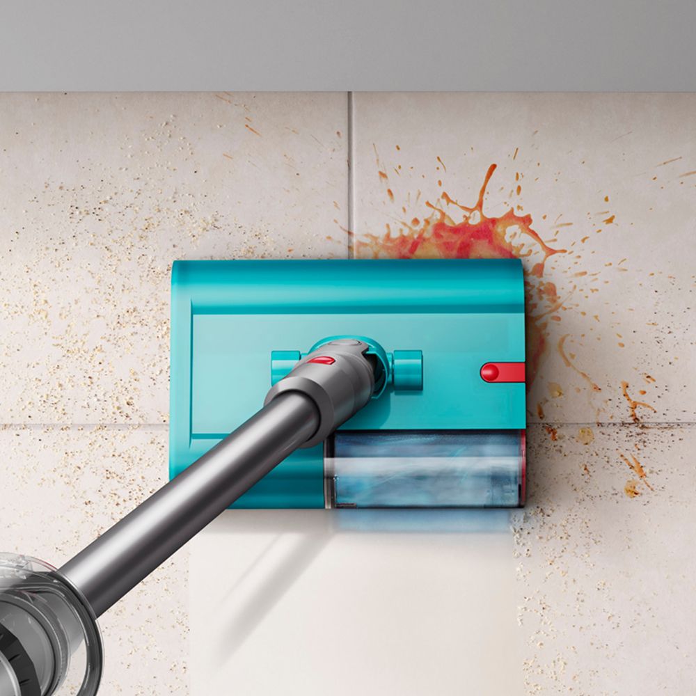 The Dyson Submarine wet cleaner head cleans a spill from a tiled floor.