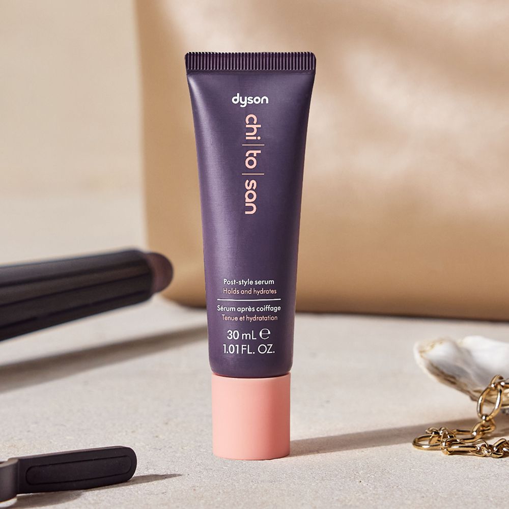 Dyson Chitosan Post-style serum travel mini beside a toiletries bag.