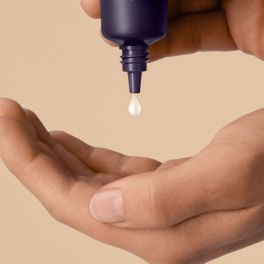 Dyson Chitosan Post-style serum travel mini squeezed into a palm.