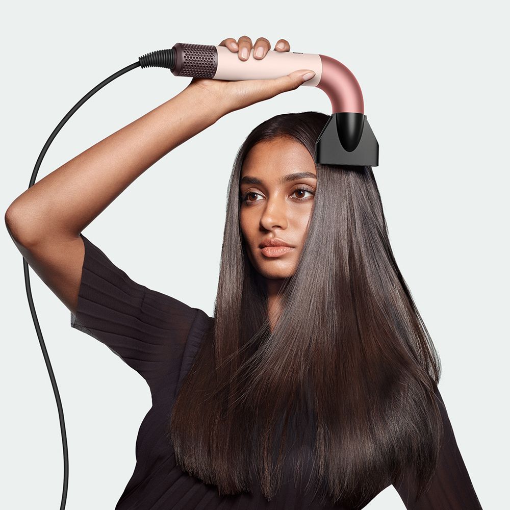 Dyson Supersonic r hair dryer used by a model to style her hair.