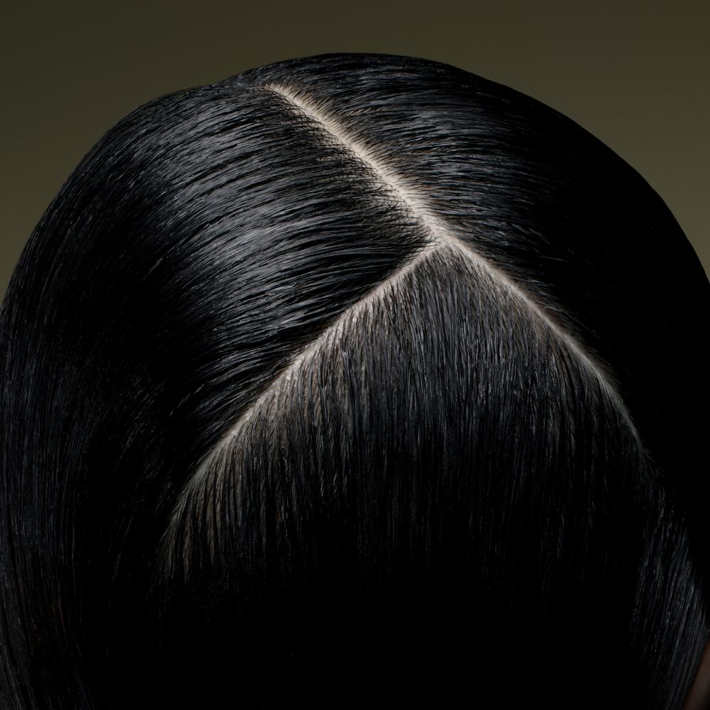 Close-up of the scalp of a model with hair treated using Dyson Amino scalp care.