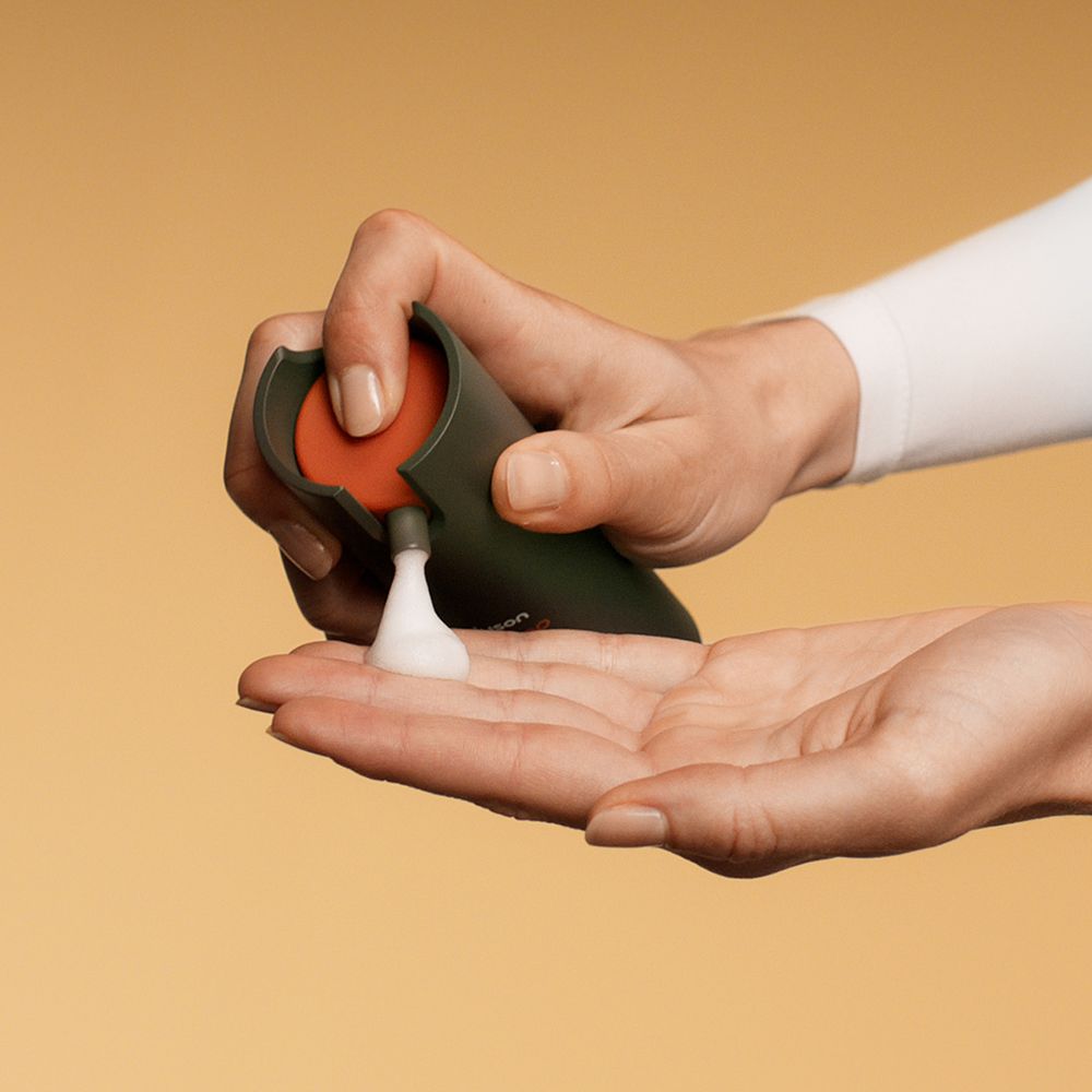 Dyson Amino leave-in scalp bubble treatment dispensed into hand.