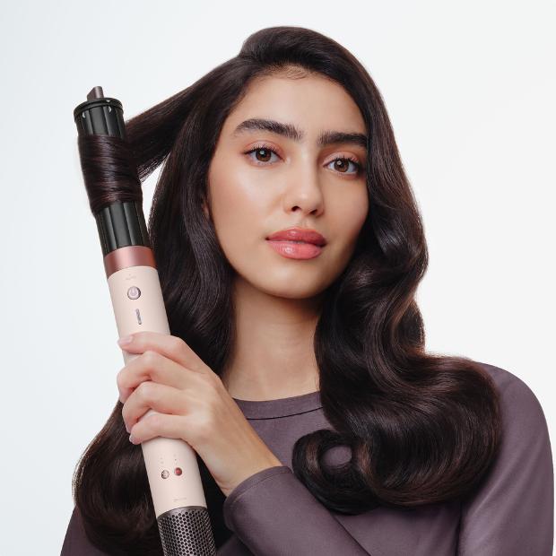 Model curls her hair with the Dyson Airwrap Co-anda2x multi-styler and dryer.