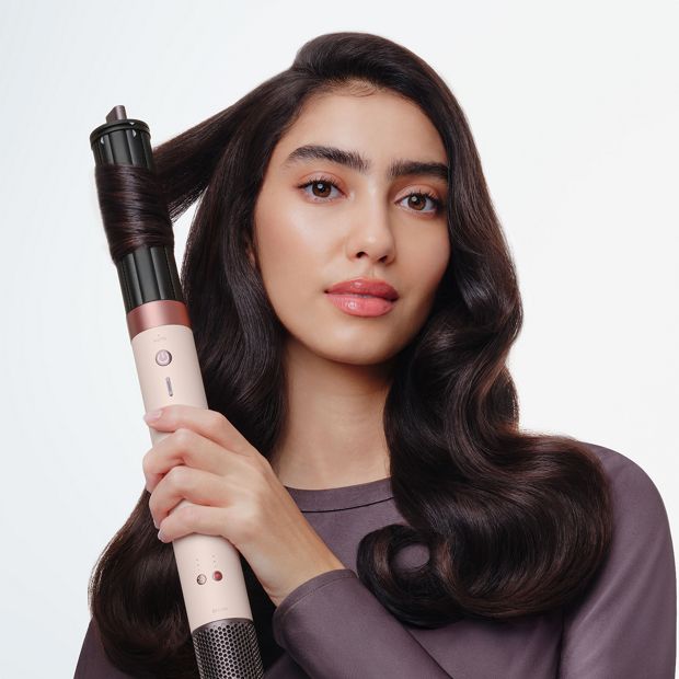 Model curls her hair with the Dyson Airwrap Co-anda2x multi-styler and dryer.