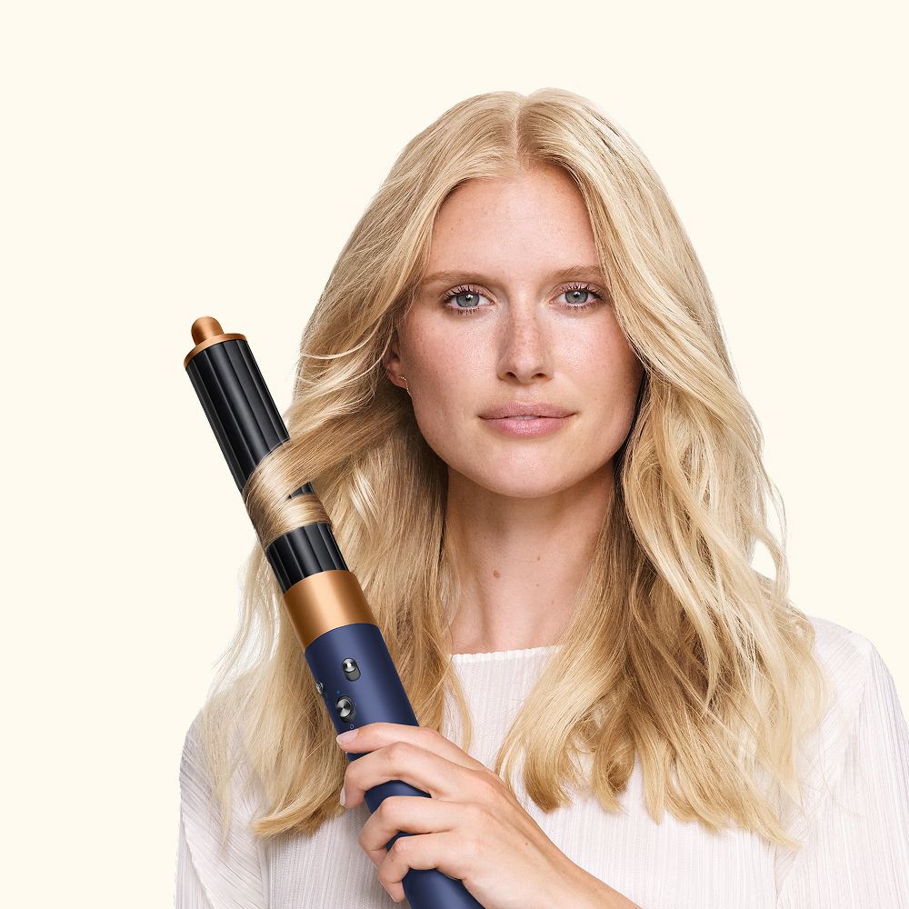 Model using the Dyson Airwrap Origin multi-styler and dryer to curl her hair.