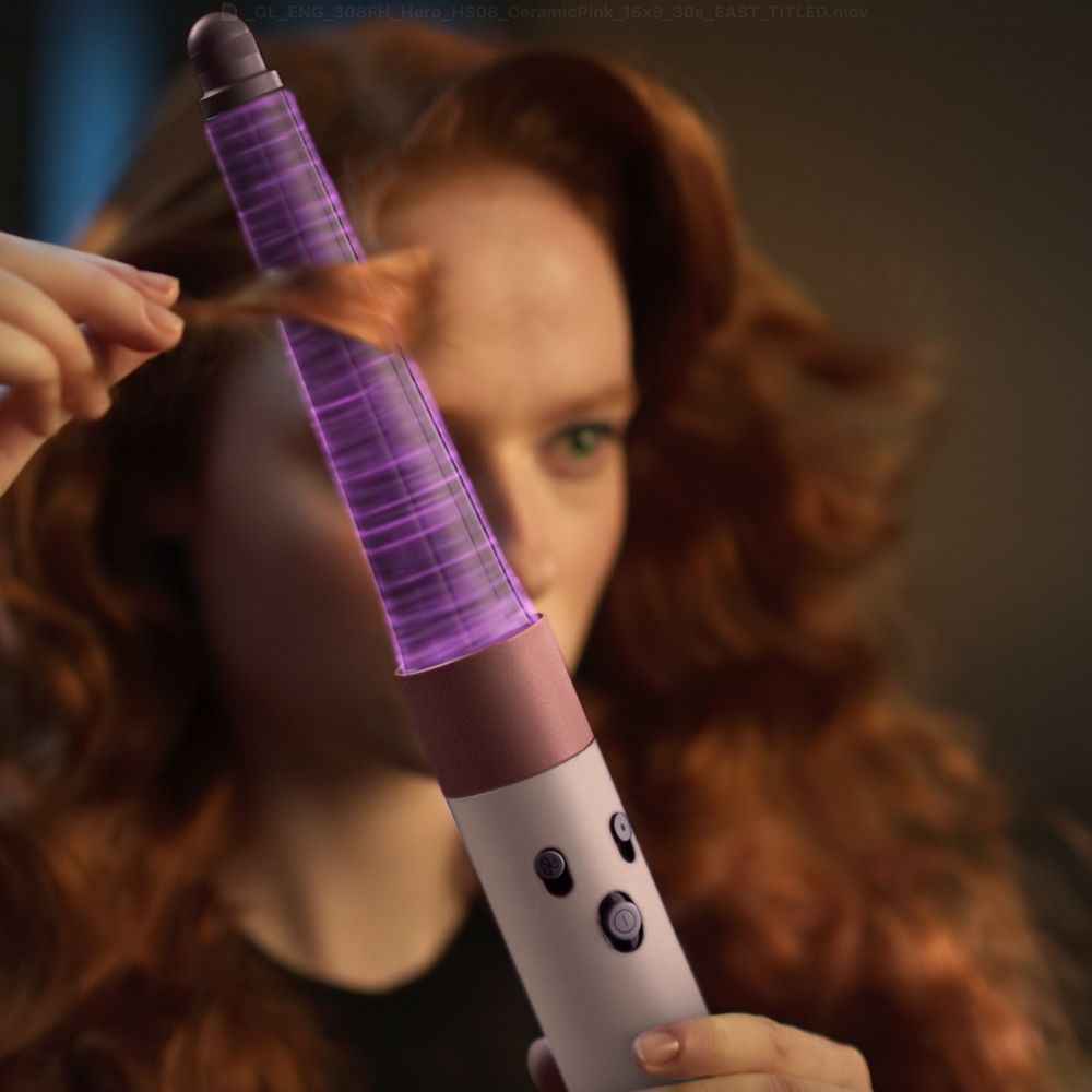 A model uses the Dyson Airwrap i.d. multi-styler and dryer to curl her hair.