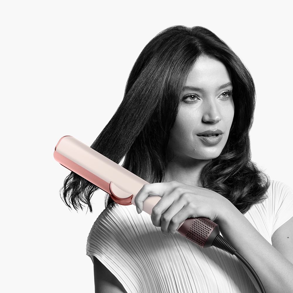  A model styles hair with the Dyson Airstrait.