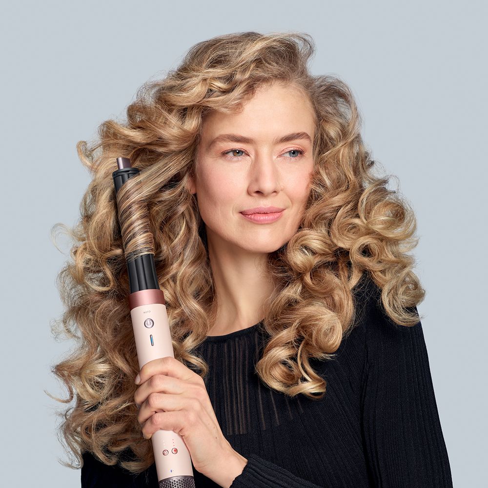 Dyson Airwrap Co-anda2x multi-styler and dryer used by a model to style her hair.