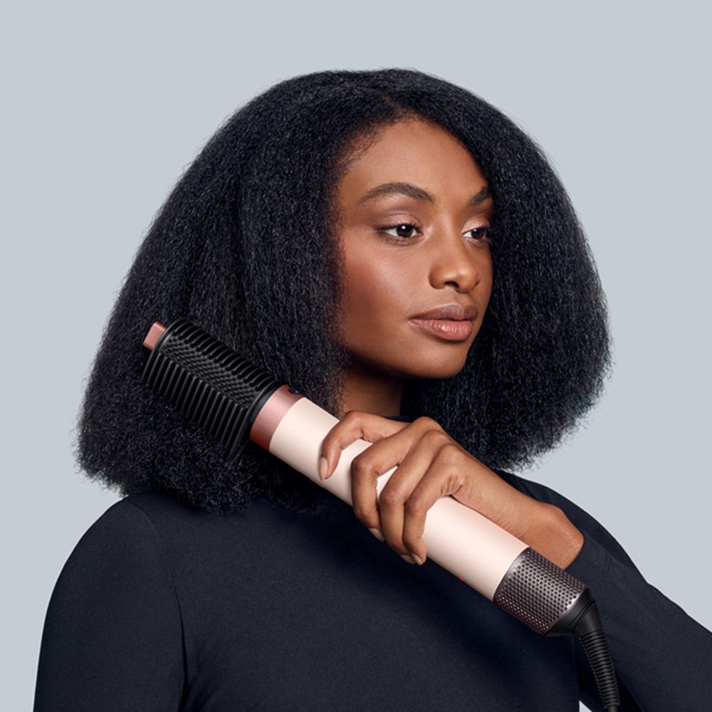 Dyson Airwrap Co-anda2x multi-styler and dryer used by a model to style her hair.