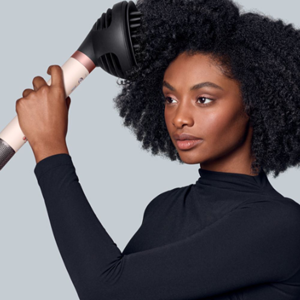 Dyson Airwrap Co-anda2x multi-styler and dryer used by a model to dry her hair.