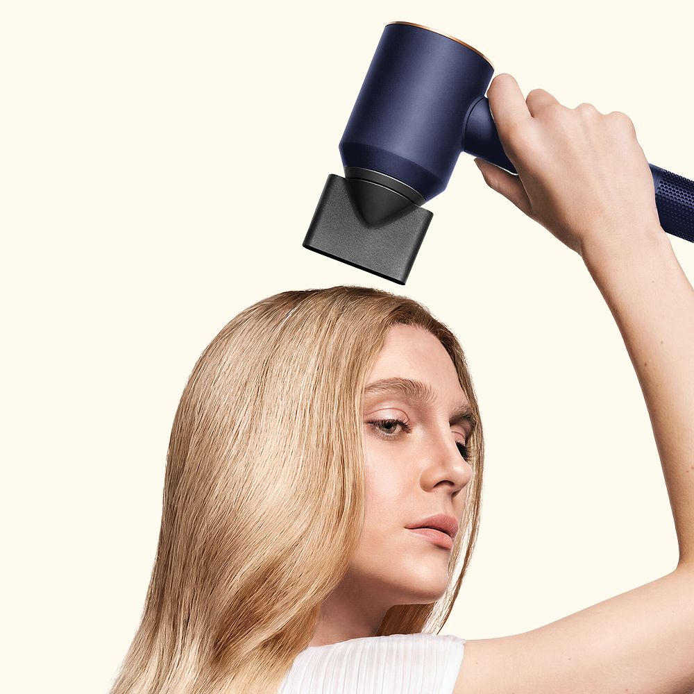 Model dries her hair using the Dyson Supersonic Origin hair dryer.