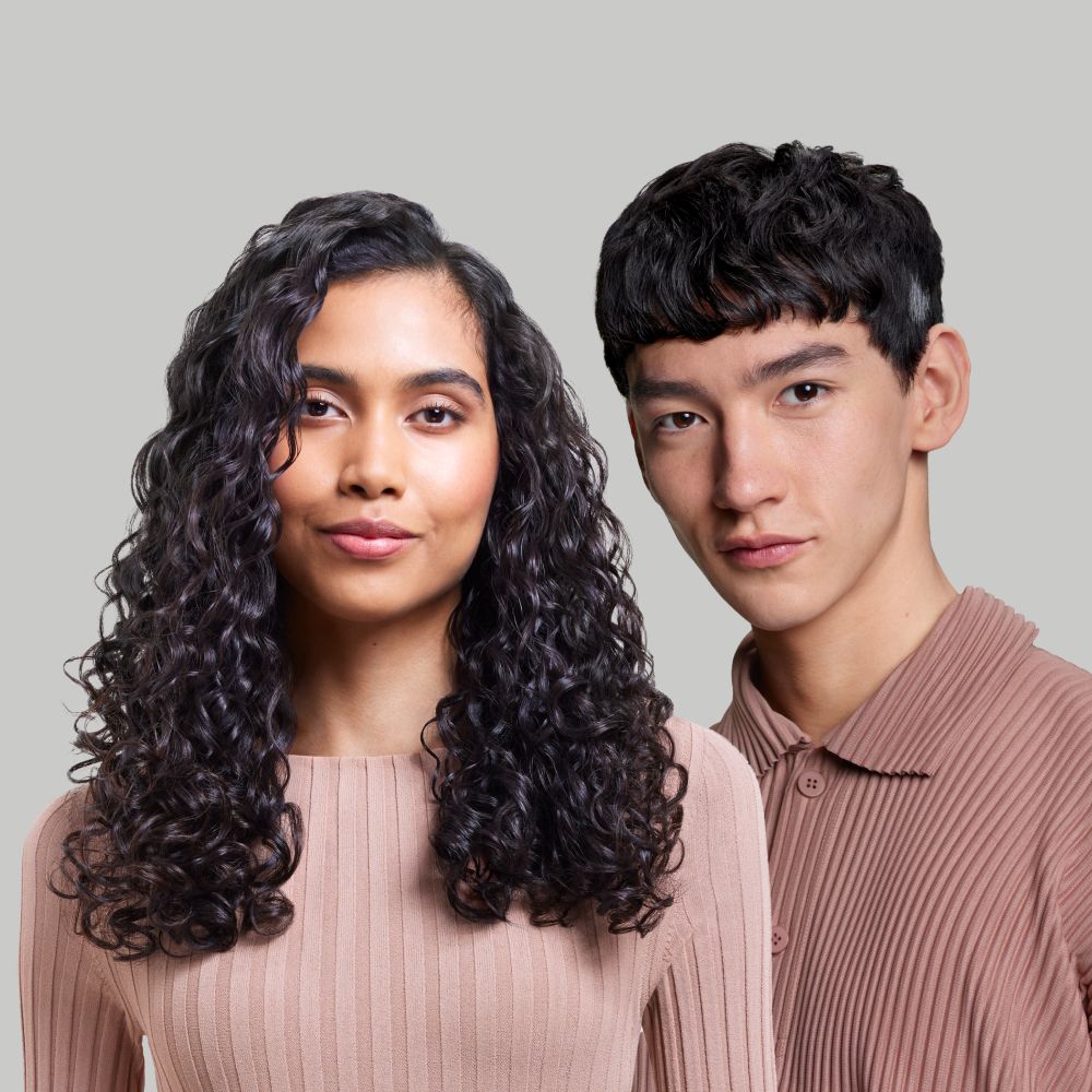 Par modela s kosom oblikovanom Dyson Supersonic Nural sušilom za kosu.