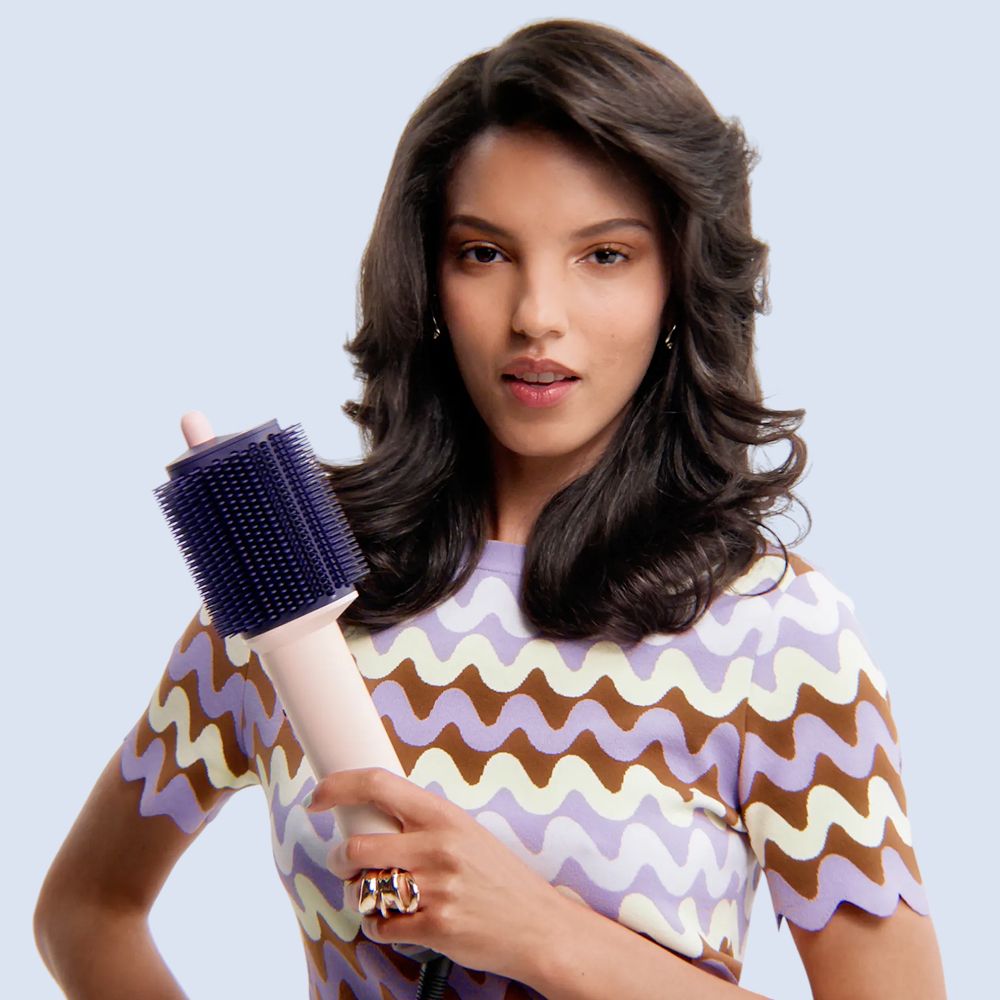 Dyson Supersonic Travel hair dryer held in a hand.