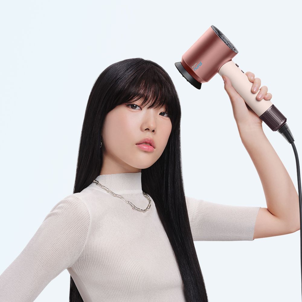 Model uses the Dyson Supersonic Nural hair dryer to style her hair.