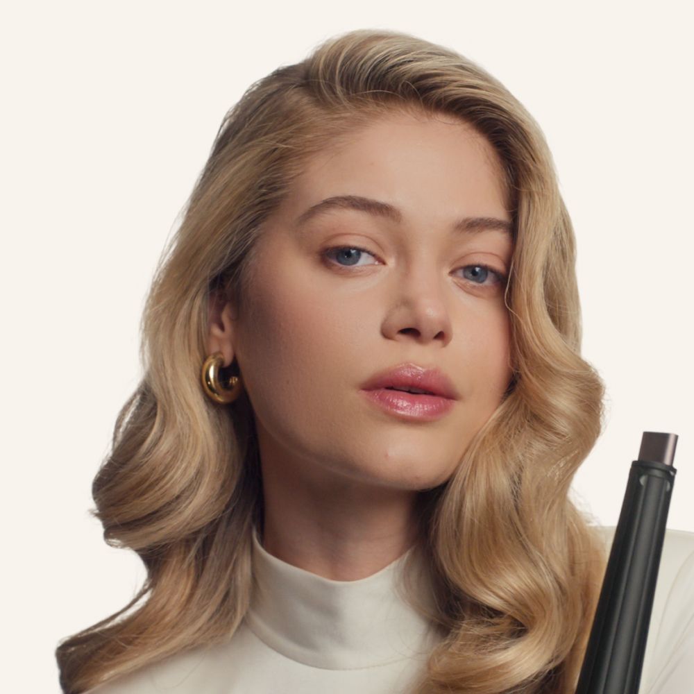 Model with wavy hair styled with the Dyson Airwrap Co-anda2x multi-styler and dryer.