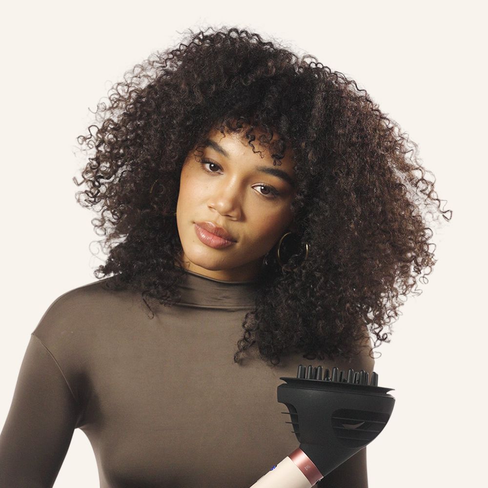 Model diffuses her hair with the Dyson Airwrap Co-anda2x multi-styler and dryer.