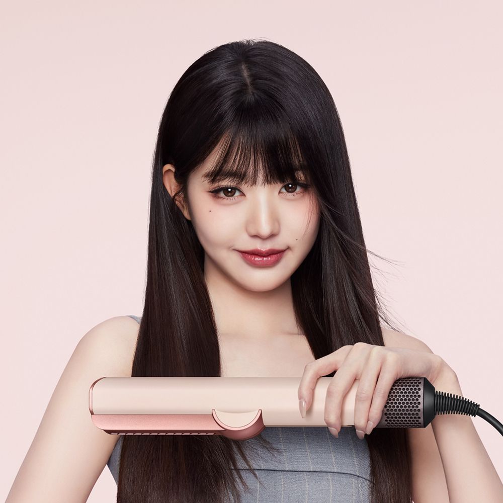 模特兒使用 Dyson Airstrait 二合一吹風直髮器拉直頭髮。