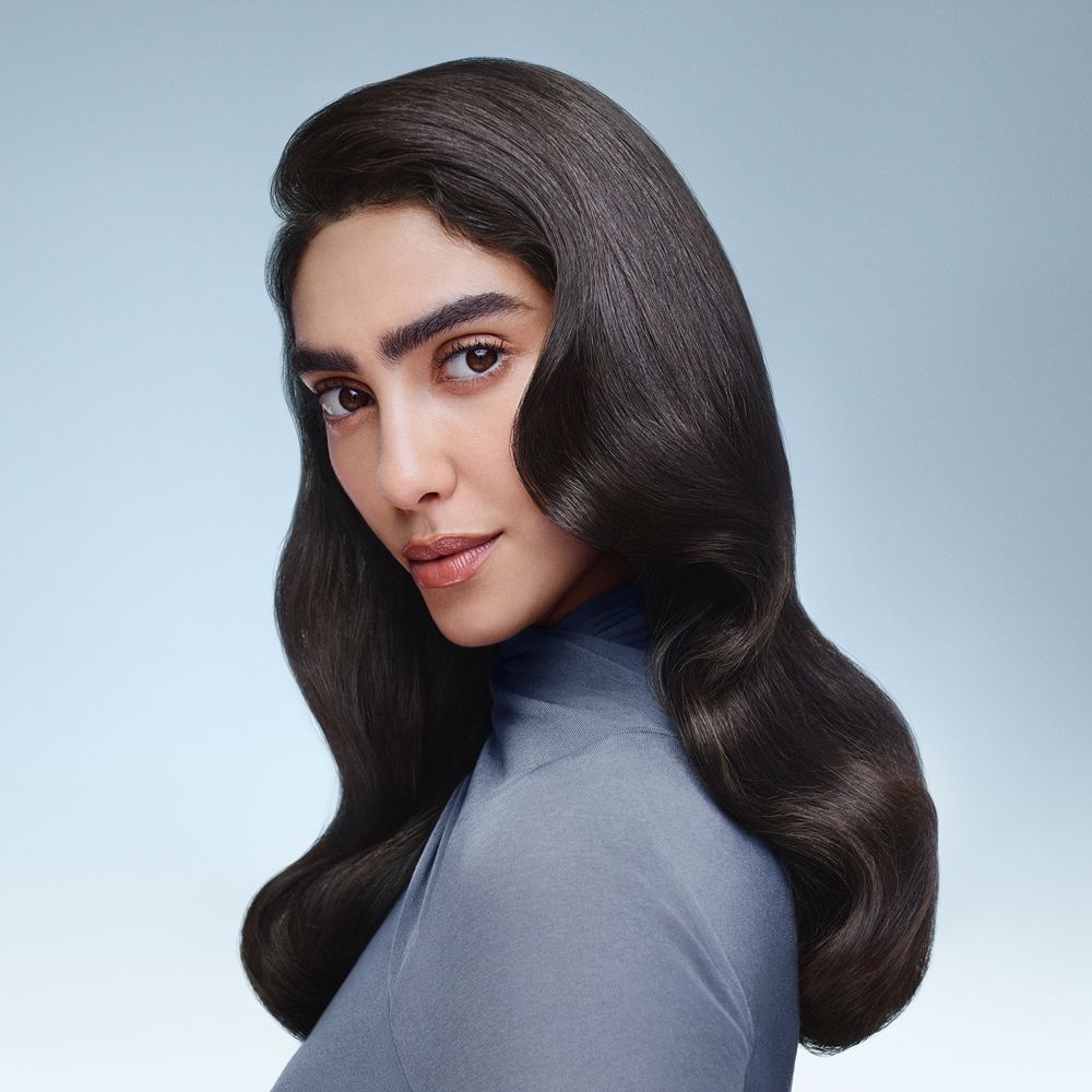 Das Model präsentiert glattes, geschmeidiges, welliges Haar, das mit Dyson Beauty-Geräten gestylt wurde.