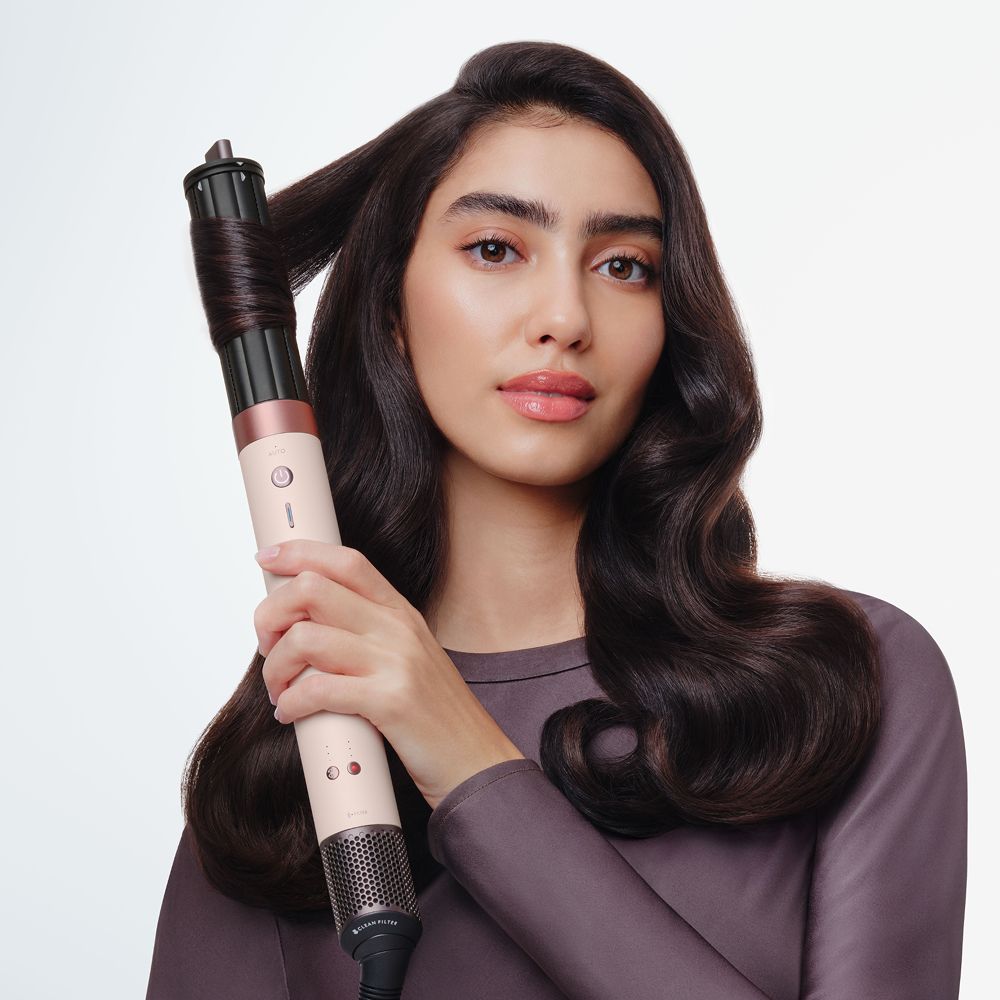 Model uses the Dyson Airwrap Co-anda2x multi-styler and dryer to style her hair.