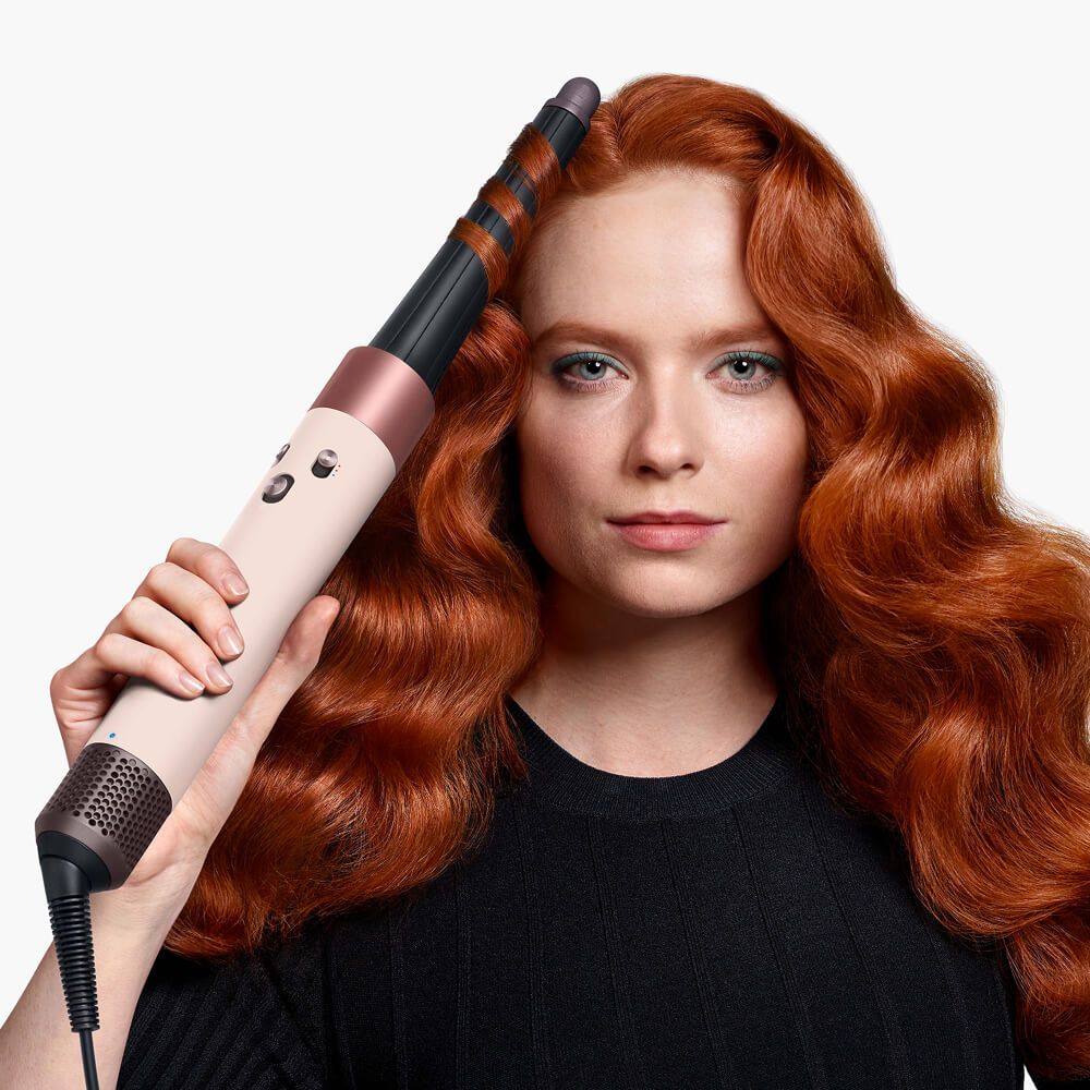 Model uses the Dyson Airwrap I.D. multi-styler and dryer to style her hair.