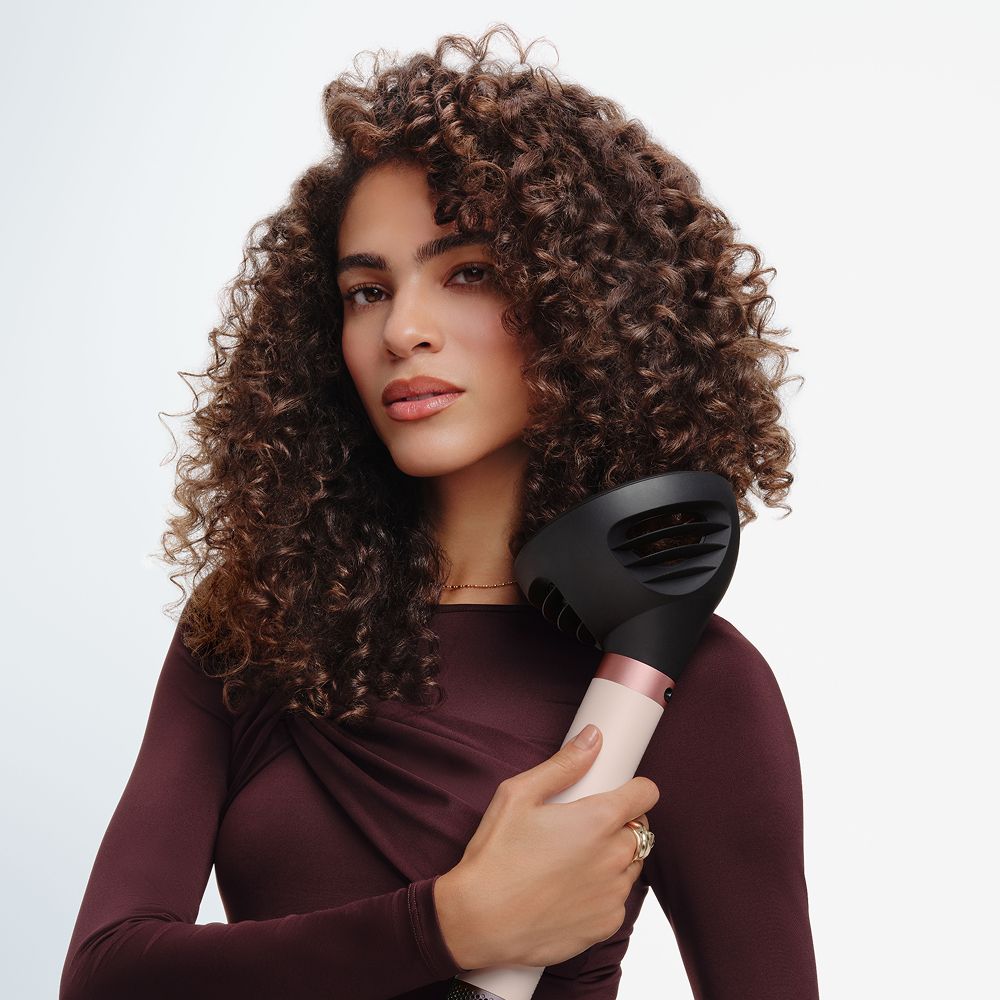 Model styles her hair with a Dyson multi-styler and dryer.