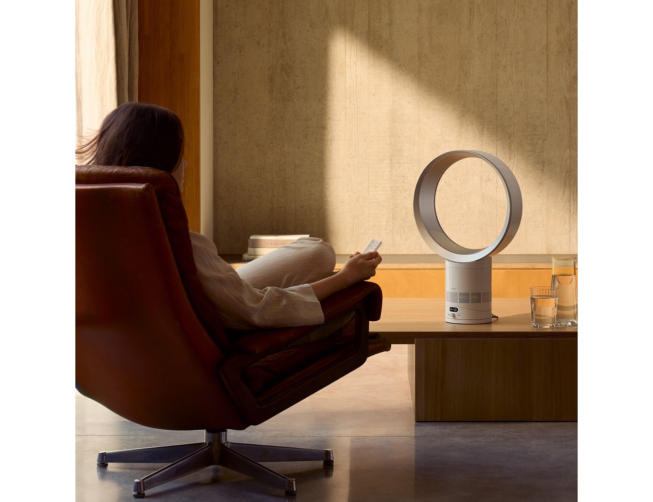 Personne réglant le Dyson Cool CF1 à la télécommande depuis son fauteuil