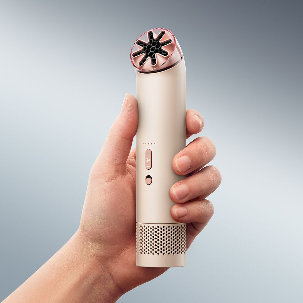 Dyson HushJet Mini Cool portable fan held in a hand.