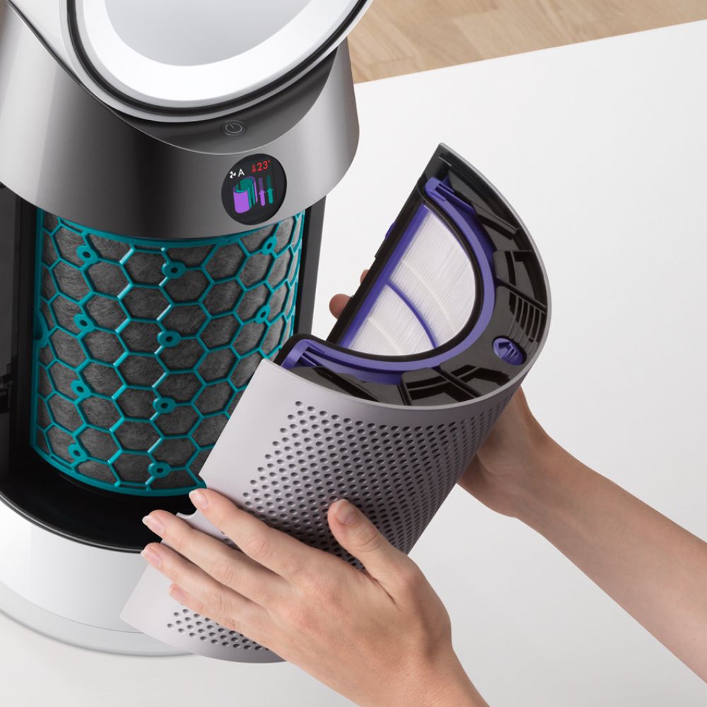 A model removes the filter cover from a Dyson purifier.