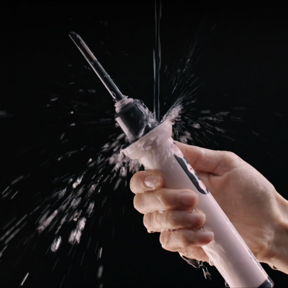 Dyson CameraJet toothbrush splashed with water.