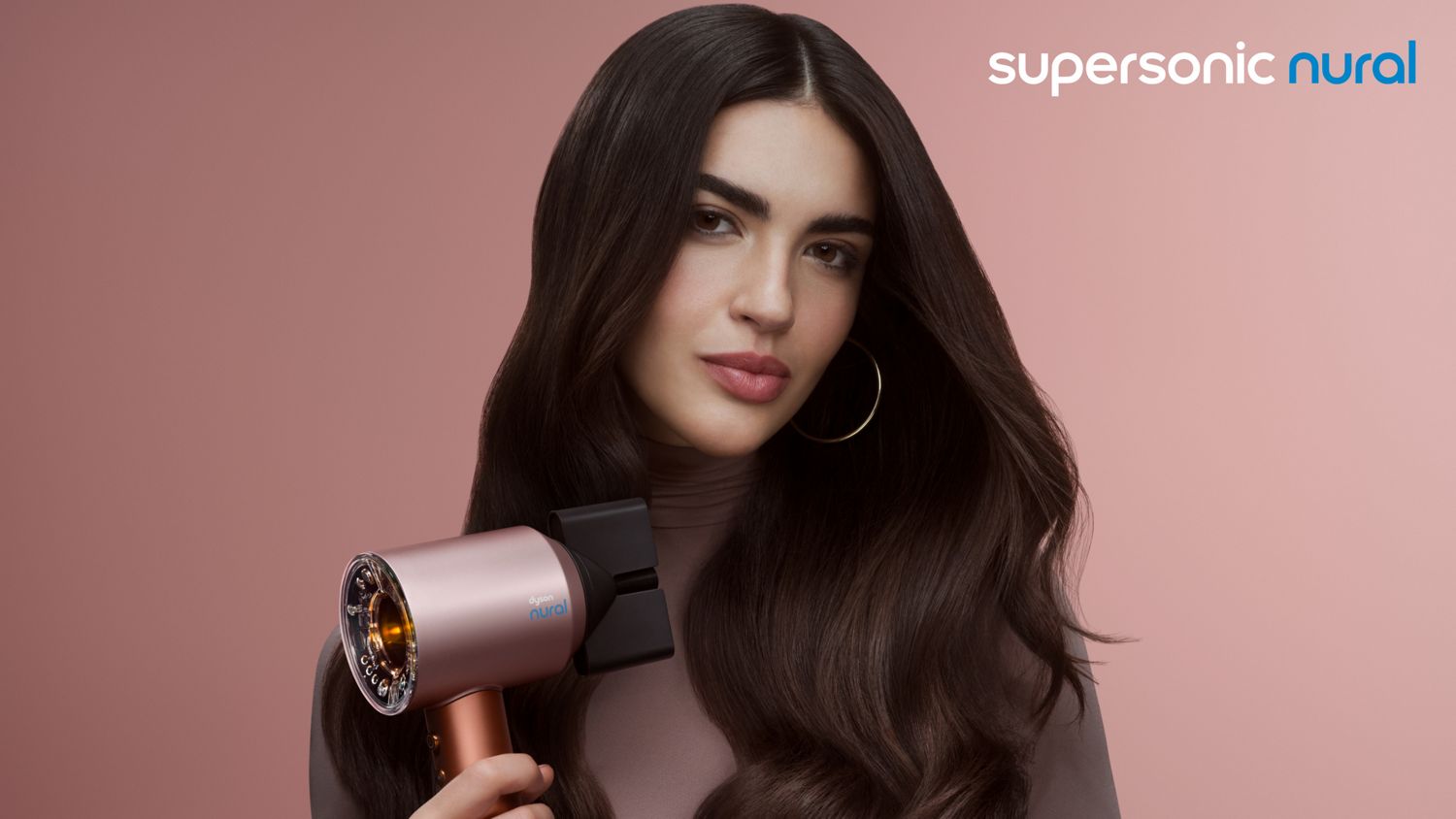 The Dyson Supersonic Nural is held by a model.
