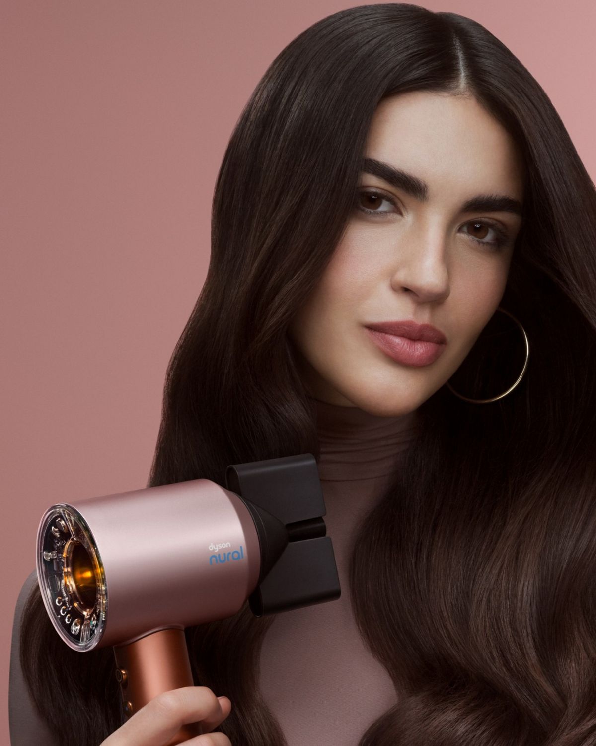 The Dyson Supersonic Nural is held by a model.