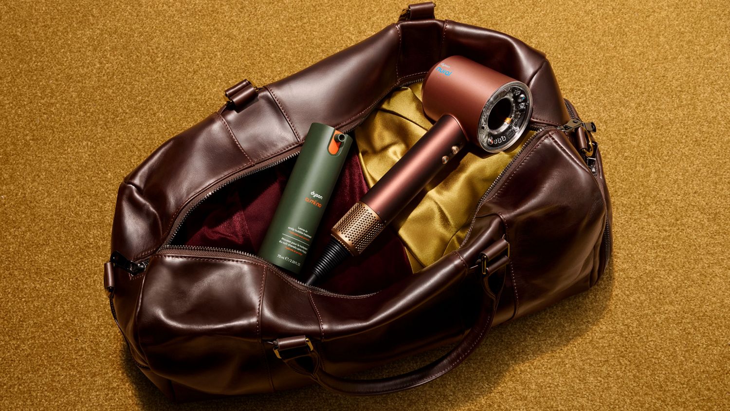 Dyson Supersonic Nural hair dryer in a bag with Dyson Amino leave-in scalp bubble treatment.