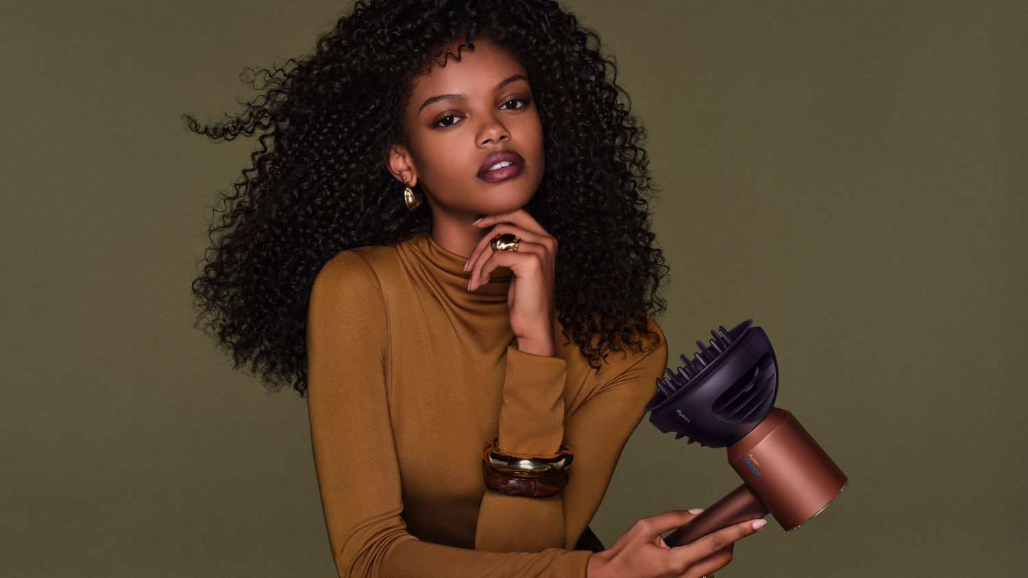 Model diffuses her hair with the Dyson Supersonic Nural hair dryer.