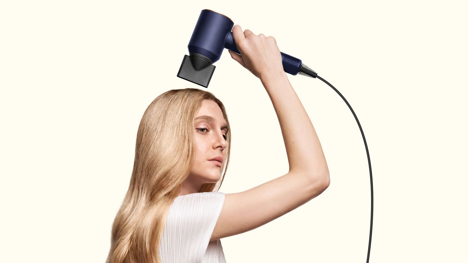 Model dries her hair using the Dyson Supersonic Origin hair dryer.