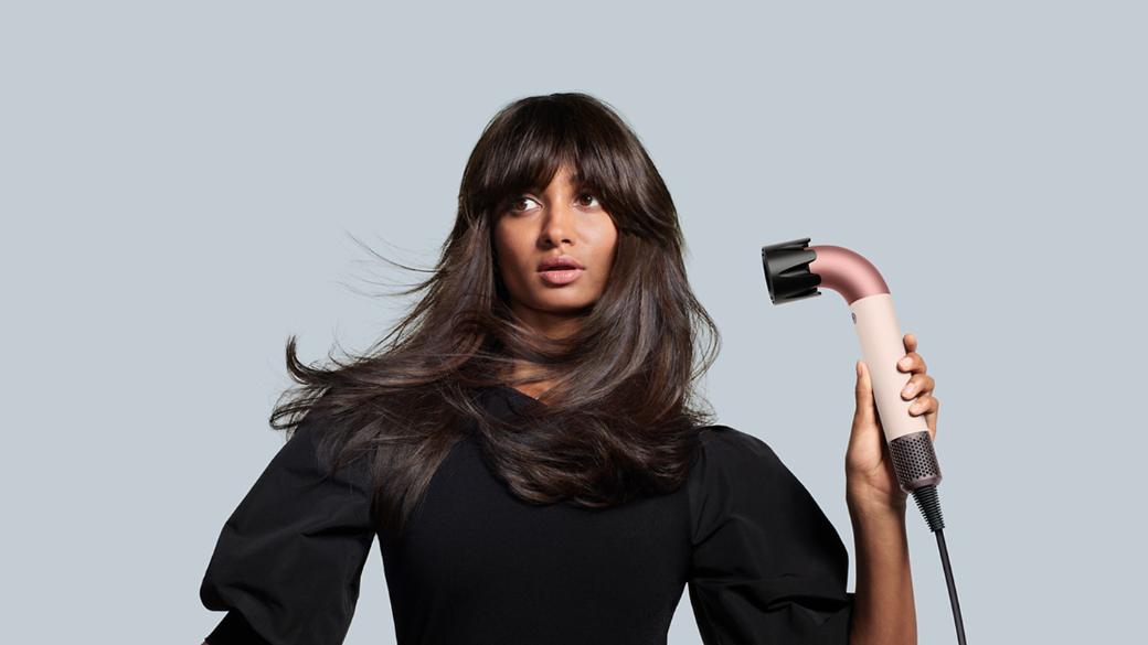 Female model holding the Dyson Supersonic r with the Smoothing Nozzle attachment.