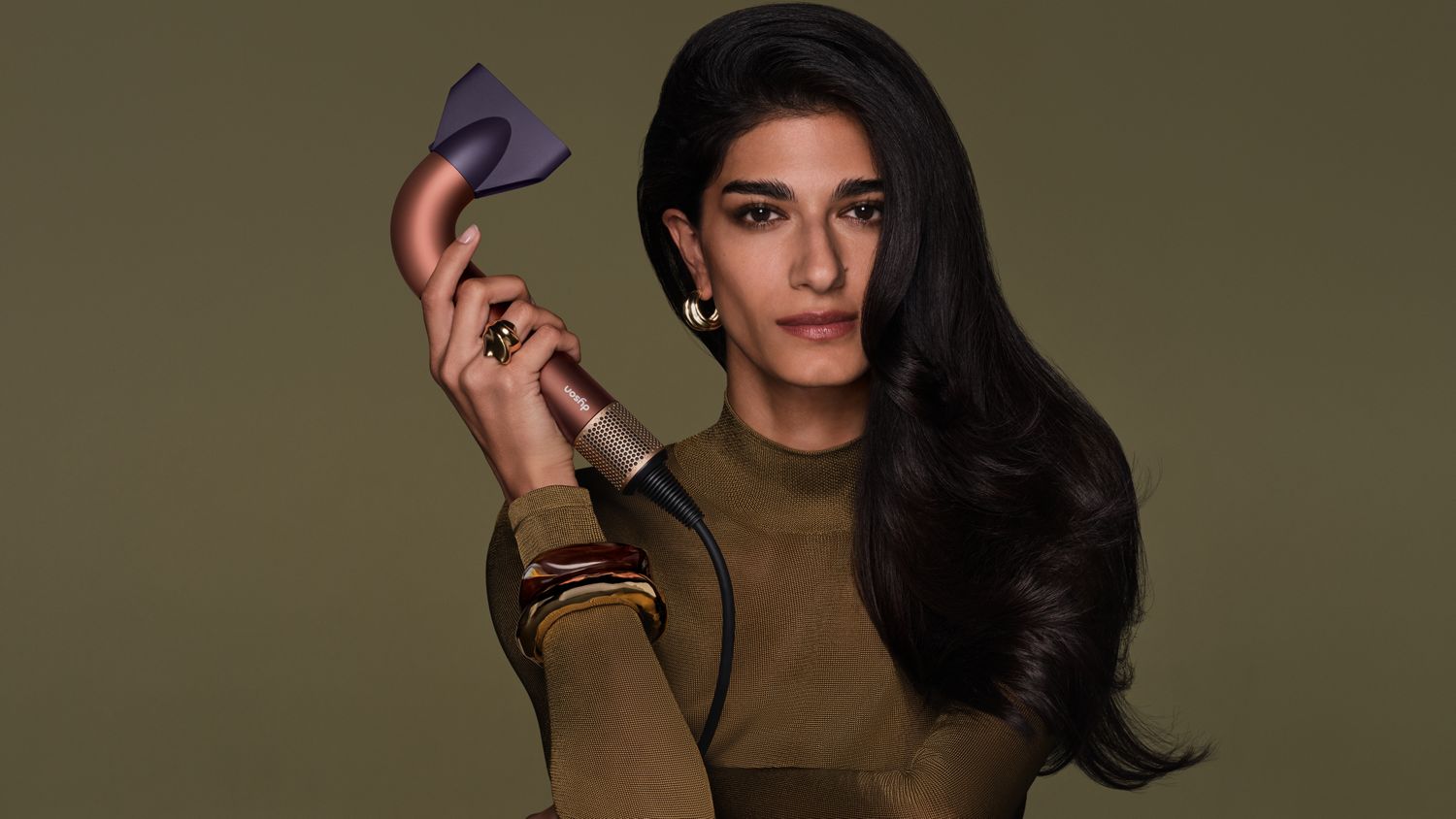 Model holds the Dyson Supersonic R hair dryer.