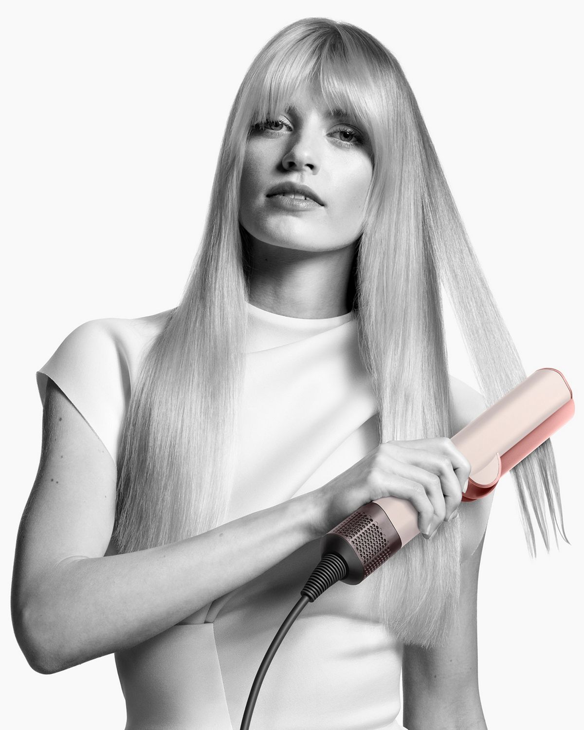 A model showing off her hair styled using the Dyson Airstrait straightener.