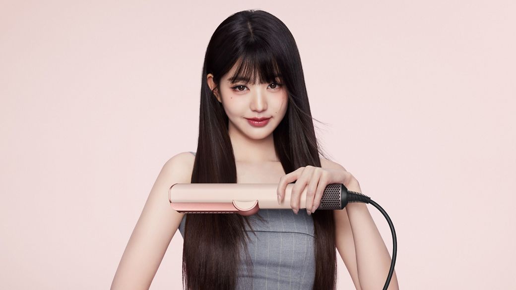 模特兒使用 Dyson Airstrait 二合一吹風直髮器，將頭髮由濕髮吹直。