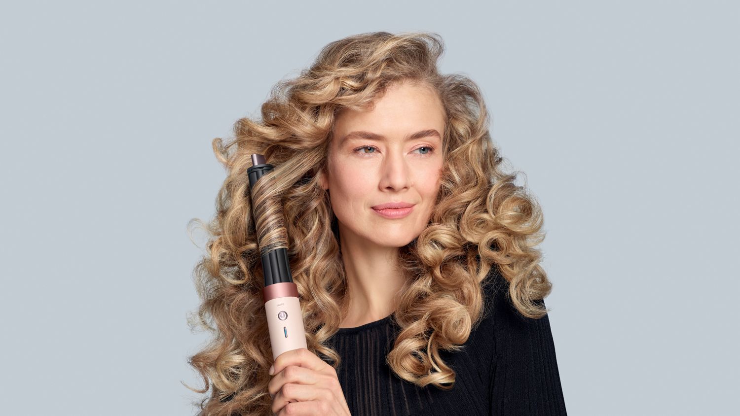 Model with wavy hair using the Dyson Airwrap Co-anda2x multi-styler and dryer.