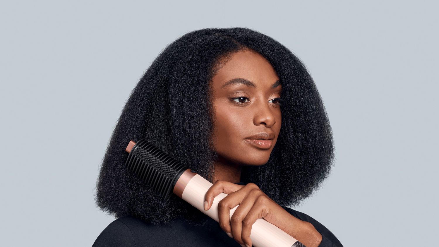 A model uses the Tension comb 2x to lengthen and straighten her hair.