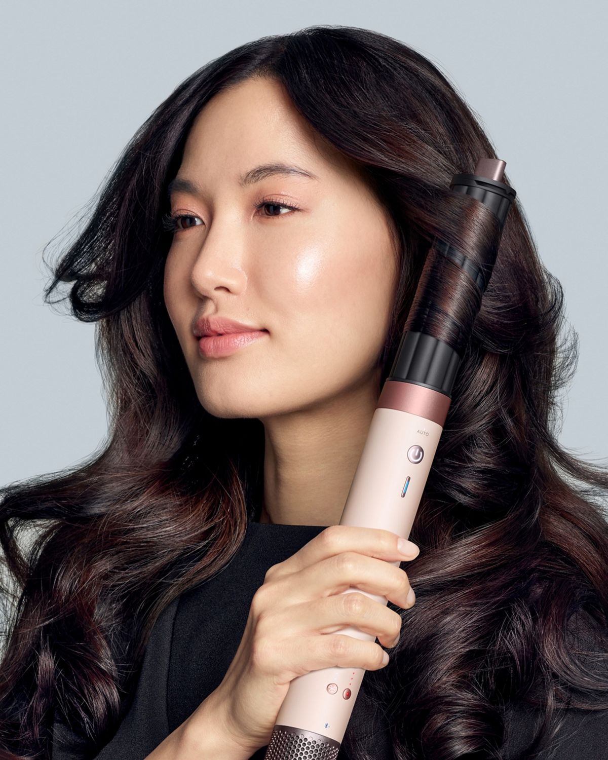 A model with dark hair adds curls using the Dyson Airwrap Co-anda2x multi-styler and dryer. The next-level multi-styler.