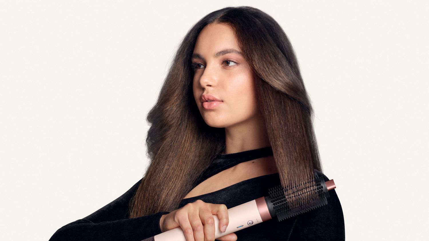 Model styles her hair with the Dyson Airwrap Co-anda2x Large round volumising brush 2x.