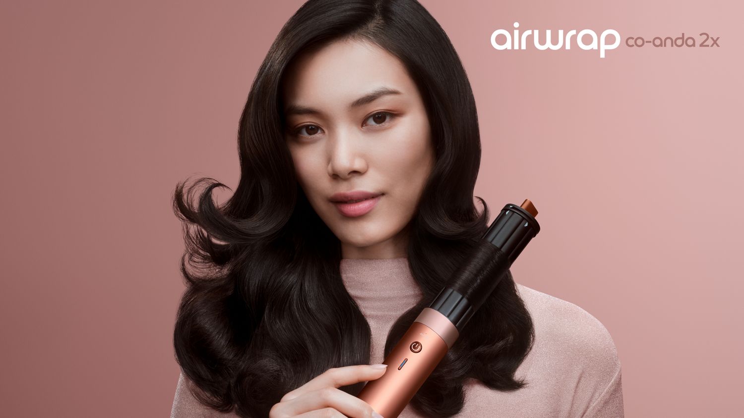 The Dyson Airwrap Coanda 2x is held by a model.
