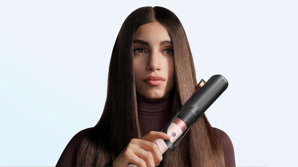 Model straightens her hair with the Dyson Air straightener 2x attachment.