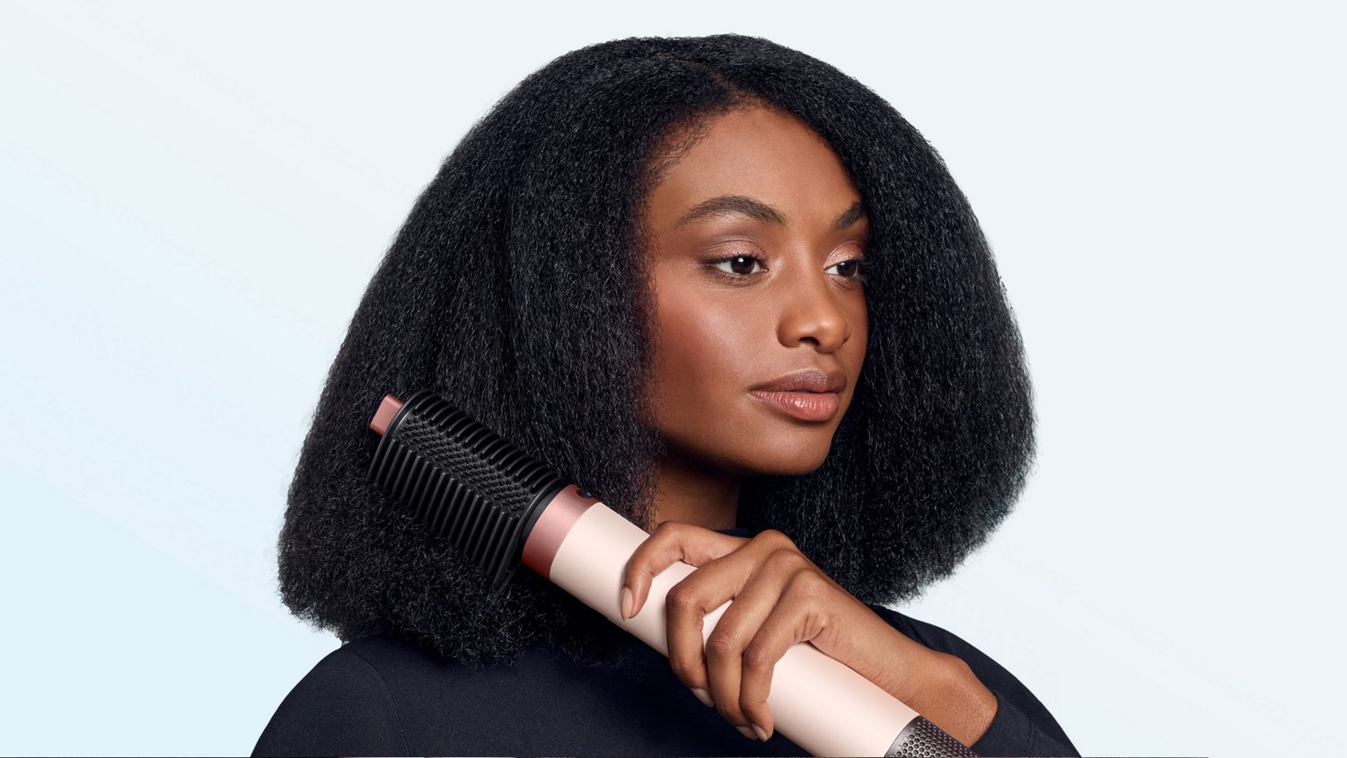 Model smooths her hair with the Tension comb 2x attachment.