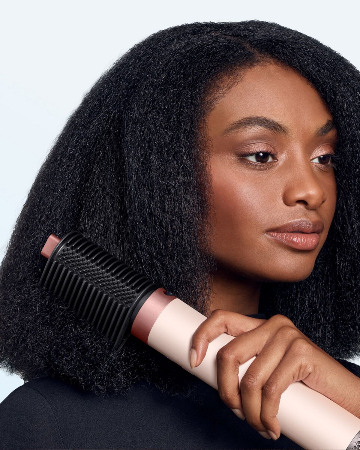Model smooths her hair with the Tension comb 2x attachment.