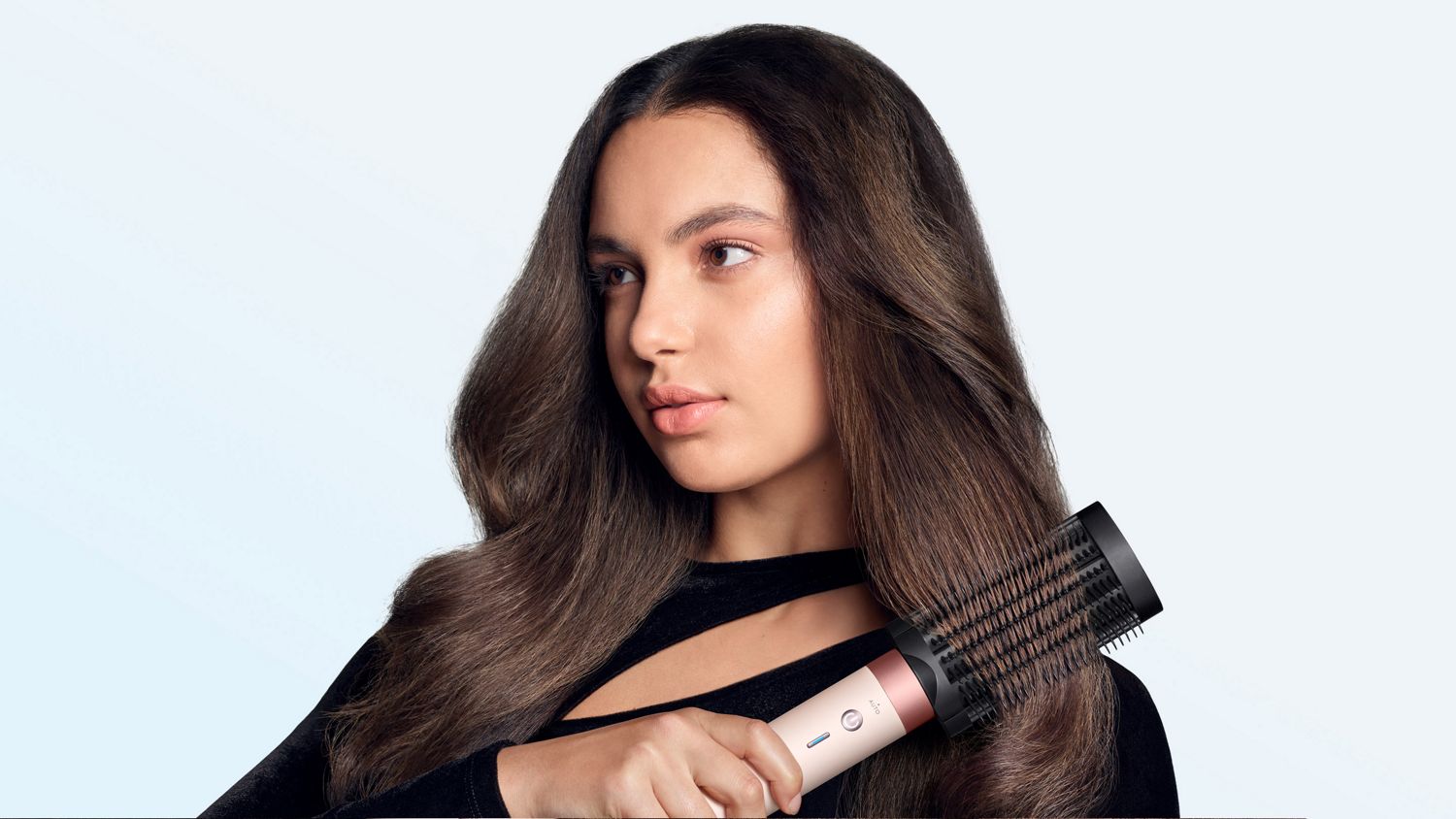 Model brushes her hair with the Dyson Anti-snag loop brush 2x.