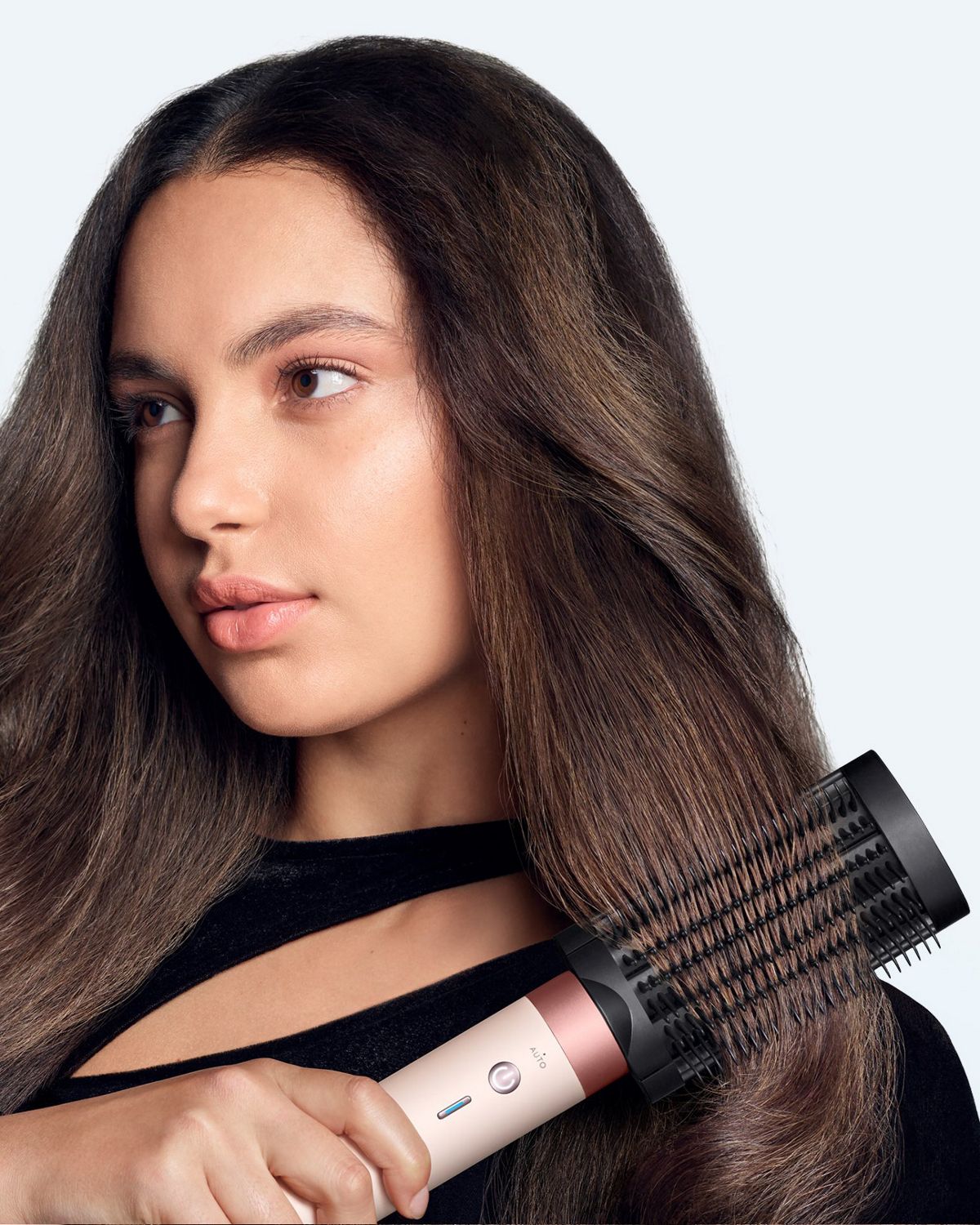 Model brushes her hair with the Dyson Anti-snag loop brush 2x.